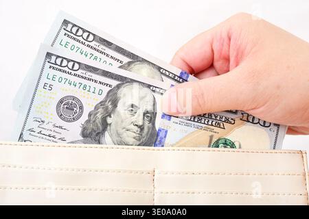 White purse with US dollars in the hands on a white background Stock Photo