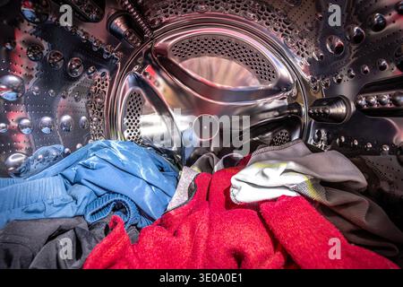 Colorful clothes inside a stainless steel washing machine drum Stock Photo