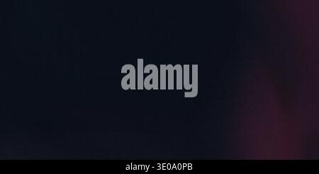 A dark, almost black or deep navy blue textured background. There is a very subtle, diffused reddish or magenta light emanating from the far right edg Stock Photo