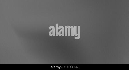 A dark shadow is cast on a gray textured surface with a subtle gradient effect, creating a sense of depth and dimensionality Stock Photo