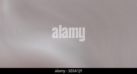 A light gray background featuring a soft, brushed texture that suggests either fine metal or a woven fabric, with gentle highlights and shadows creati Stock Photo