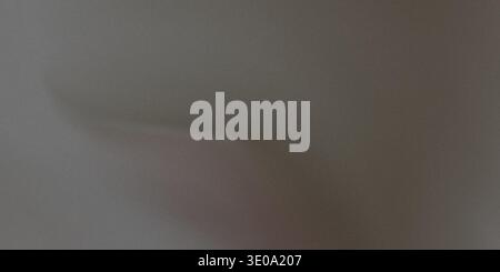 A close-up view of a dark gray fabric with a subtle sheen, showcasing soft folds and a smooth texture, ideal for backgrounds or design elements. Stock Photo