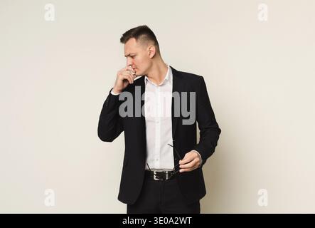 Pensive businessman with glasses in hand Stock Photo