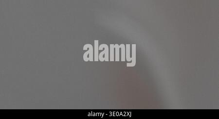 A close-up photograph of a medium gray material, likely fabric, exhibiting gentle folds and subtle variations in shading due to soft lighting. The sur Stock Photo
