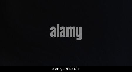 This image features a dark and sleek black background with no discernible texture or visual elements, providing a dramatic and intense visual setting Stock Photo