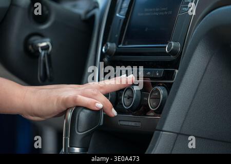 Hand adjusting car climate control air conditioning panel Stock Photo