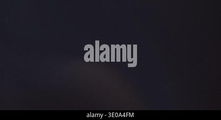 A dark colored background with a slight gradient texture and a subtle light effect in the center, creating a sense of depth and dimension. Stock Photo