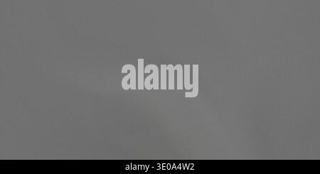 This image showcases a dark gray fabric with a subtle sheen. The fabric features gentle folds and creases, creating a sense of depth. The dark gray co Stock Photo