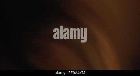 A macro shot revealing the deep, rich texture of dark brown leather, emphasizing the natural grain and folds, contrasted by strong directional lightin Stock Photo