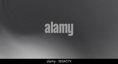 A dark gray, grainy background exhibiting significant noise and a subtle, soft gradient of light emanating from the lower left corner. This creates a Stock Photo