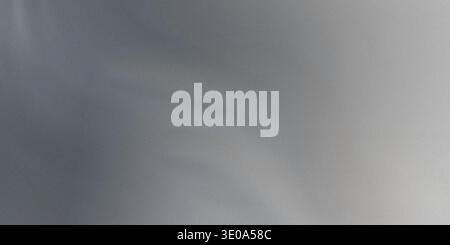 A detailed abstract background showcasing a cool, metallic silver-gray surface. The texture appears slightly brushed or grainy, with soft variations i Stock Photo