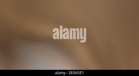 A close-up view of a warm, earthy brown textured material, possibly leather or heavy fabric. The surface shows subtle variations in tone and soft, gen Stock Photo