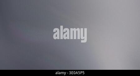 A close-up, abstract image featuring a dark to light gray metallic texture. The surface exhibits fine grain and a subtle horizontal light gradient, su Stock Photo