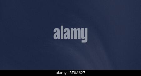 A close-up, detailed view of a deep navy blue surface exhibiting a subtle, fine-grained texture, suitable for use as a rich, dark background or materi Stock Photo