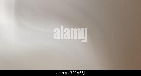 An abstract image showcasing a subtle gradient transitioning from light beige or silver tones to deeper brown shades. The surface exhibits a fine, uni Stock Photo