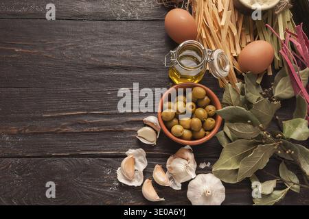 Collage of Cooking Ingredients With Olives, Garlic, Pasta, and Eggs on Rustic Wooden Table Stock Photo
