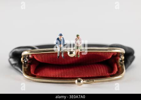 Empty purse, model figures, pensioner couple sitting on the shackle, white background, Stock Photo