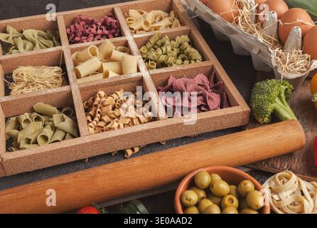 Mosaic of Different Types of Pasta With Vegetables and Eggs on a Wooden Table Stock Photo