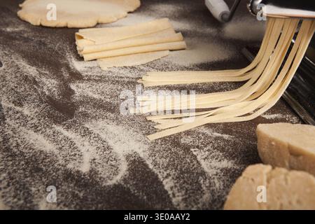 Preparing homemade fettuccine on pasta machine Stock Photo
