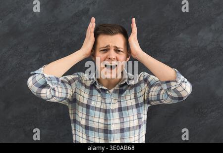 Irritated young man in stress screaming loudly Stock Photo