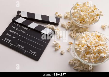 Clapperboard and popcorn on white background Stock Photo