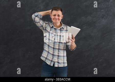 Disappointed caucasian man using tablet Stock Photo