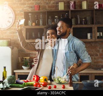 Happy black couple taking selfie at kitchen Stock Photo