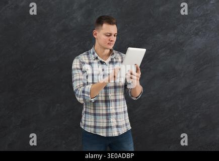 Young serious man using digital tablet Stock Photo