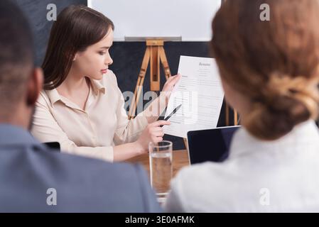 Young woman holding her resume during interview Stock Photo