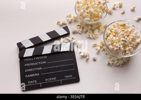 Clapperboard and popcorn on white background Stock Photo