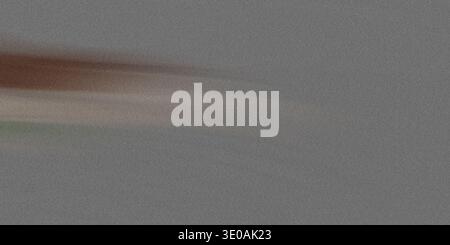 A close-up abstract image featuring a dense gray noise or static texture. A subtle, horizontal streak of brownish and light colors runs across the lef Stock Photo