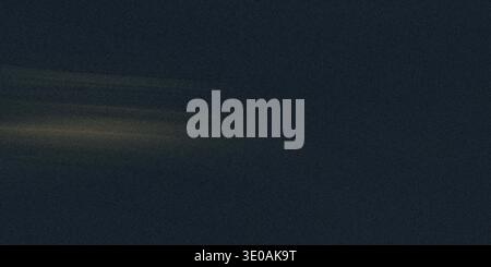A dark, deep navy blue textured background with a very subtle, horizontal streak of pale golden light near the center-left, creating a moody and sophi Stock Photo