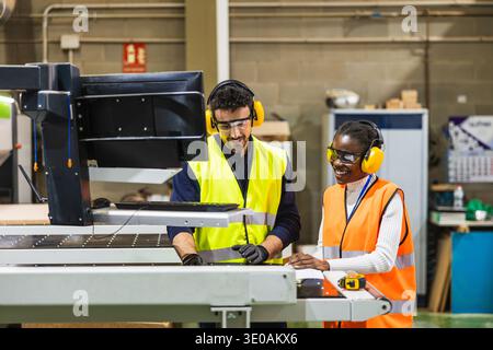 Diverse industrial workers collaborating on cnc machine control Stock Photo