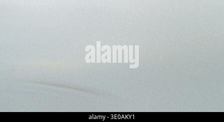 A close-up view of a light gray or silver surface with a fine, glittering texture resembling fine sand or glitter. There are very faint, slightly dark Stock Photo