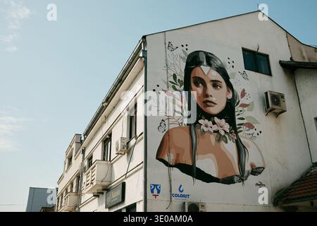 Large colorful mural of a woman painted on the side wall of a residential building representing modern street art culture in the city. Bijeljina Stock Photo