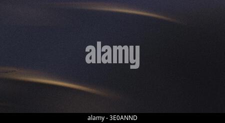 An abstract, dark, grainy texture featuring two subtle, curved streaks of golden light across the surface. The overall mood is deep and sophisticated, Stock Photo