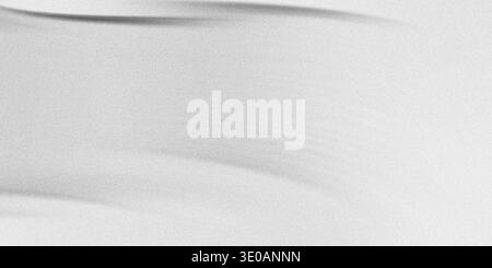 A high-key abstract image resembling fine white sand dunes or a textured surface, characterized by subtle, soft grey shadows creating gentle curves an Stock Photo