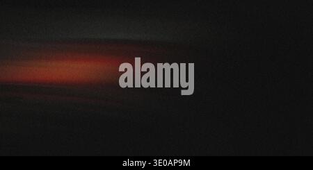 A dark, heavily textured abstract image dominated by black and deep gray tones, featuring a single, faint horizontal streak of warm orange light near Stock Photo