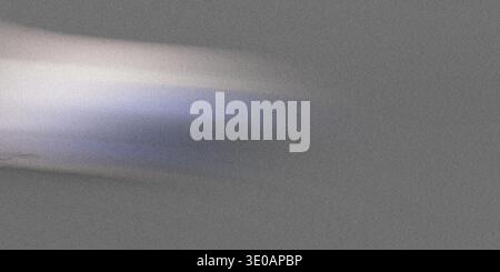 A close-up abstract image featuring a bright, slightly colored light streak moving horizontally across a dark gray, finely textured surface. The light Stock Photo
