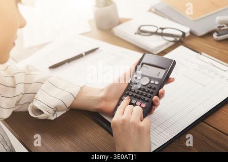 Businesswoman calculating gains and losses Stock Photo