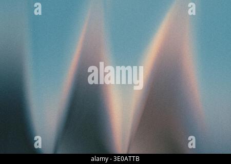 An abstract image dominated by a grainy, textured blue background. Prominent, soft, triangular shapes or peaks emerge, highlighted by subtle warm ligh Stock Photo