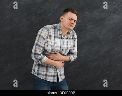 Frustrated handsome young man with stomachache Stock Photo