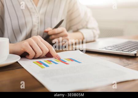 Woman analyzing business statistics holding diagrams Stock Photo