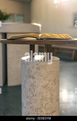 Open Bible on a stand in sun rays. Light and faith. Stock Photo