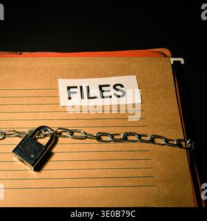 File folder labeled files with chain and padlock on dark background, conceptual image of document security, restricted access, privacy and protected i Stock Photo