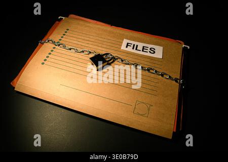 File folder labeled files secured with chain and padlock, conceptual image of locked records, restricted access, confidentiality and information prote Stock Photo
