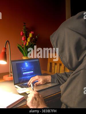 Person writing a password on paper beside a laptop login screen, conceptual image of weak password practices, credential exposure and cybersecurity ri Stock Photo