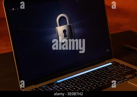 Laptop with a lock symbol on a dark screen, conceptual image of data protection, device security, privacy, encryption and secure digital access. Stock Photo