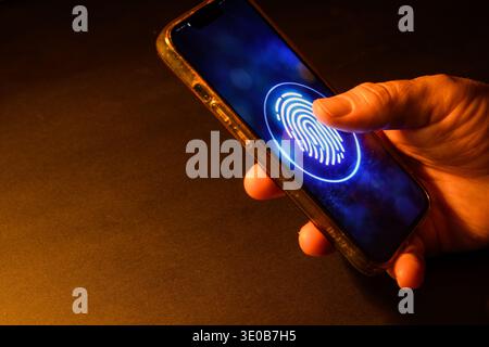 Hand using fingerprint authentication on a smartphone screen, conceptual image of biometric security, mobile login, identity verification and secure a Stock Photo