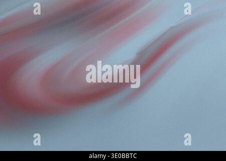 A textured blue background features a soft, flowing red wave, creating a gentle and abstract design with movement Stock Photo